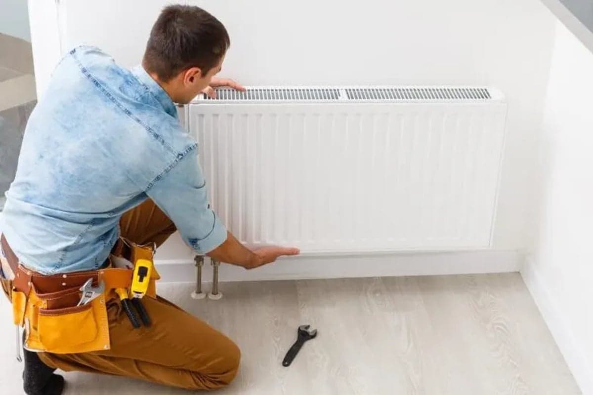 Loodgieter installeert radiator en verwarmingselement